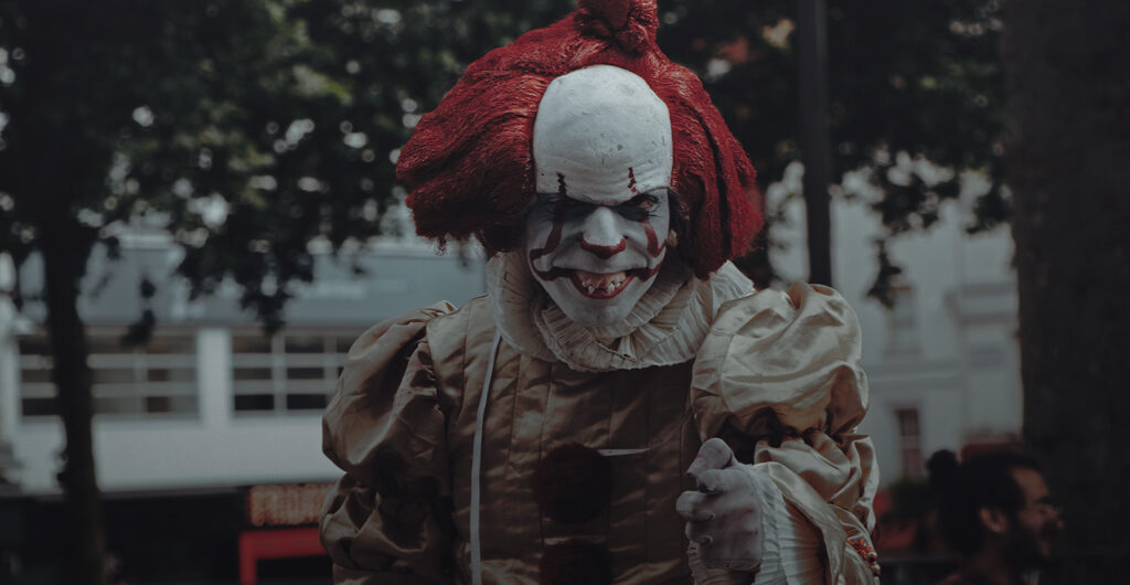 Düsteres Foto eines gruselig aussehenden Clowns auf einer Straße